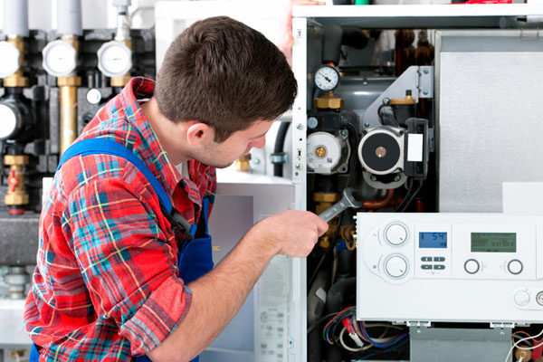 HVAC technician inspecting and repairing boiler controls in El Mirage