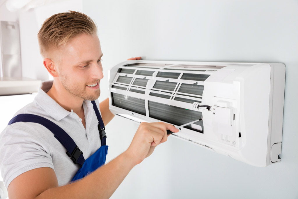 HVAC technician performing ductless air conditioning maintenance in El Mirage