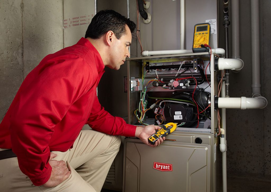HVAC technician repairing an indoor furnace in El Mirage