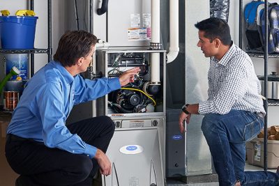 HVAC technician explaining furnace repair and maintenance to a homeowner in El Mirage, AZ