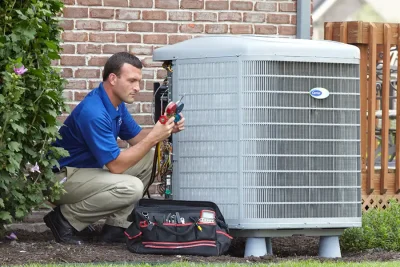 HVAC technician inspecting an outdoor air conditioning unit in El Mirage, AZ