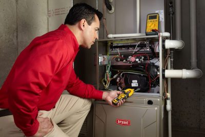 Heating and air conditioning technician servicing an indoor furnace in El Mirage, AZ